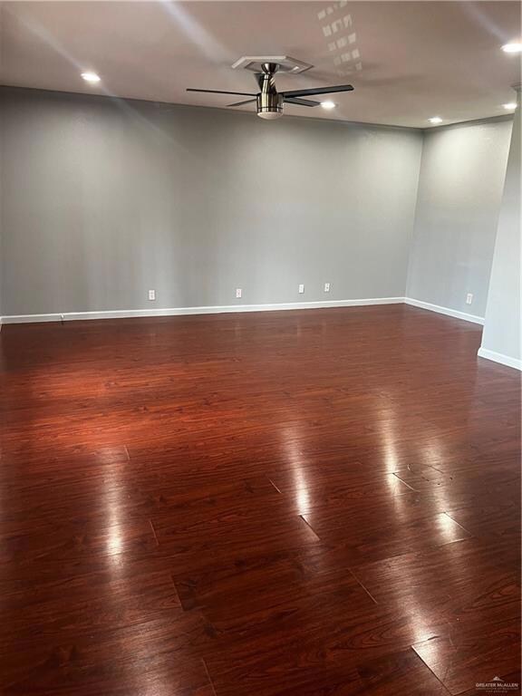 Empty room with dark wood-style floors, recessed lighting, a ceiling fan, and baseboards