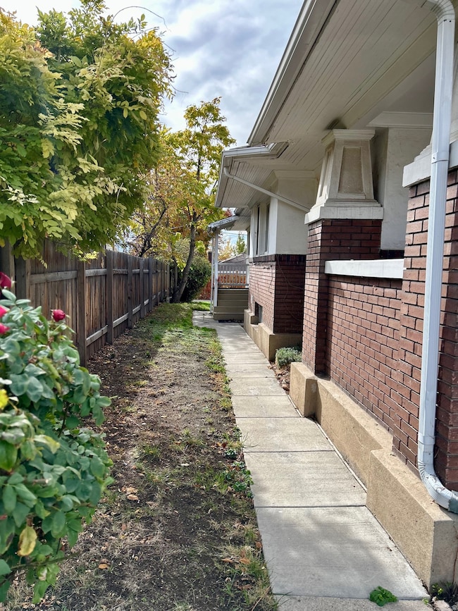 View of fenced side yard and exterior rick siding of home