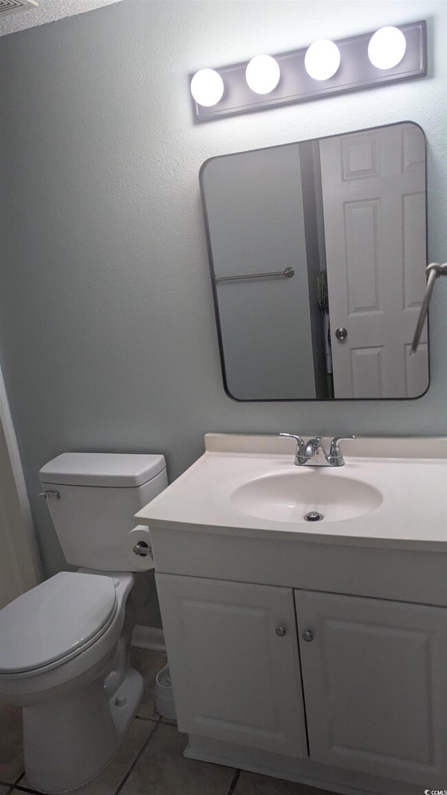 Bathroom with vanity, tile patterned flooring, and toilet