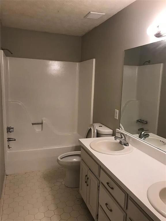 Full bathroom featuring double vanity and tub / shower combination