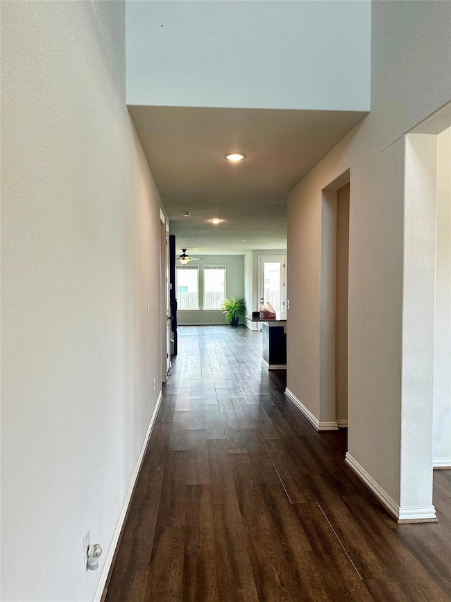 Corridor with dark wood-style floors and recessed