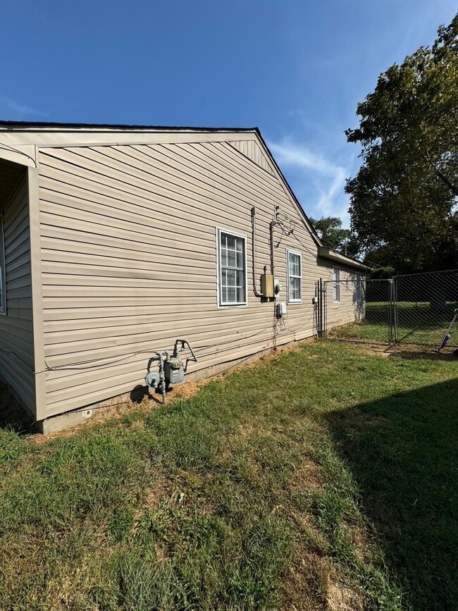View of side of property with a lawn