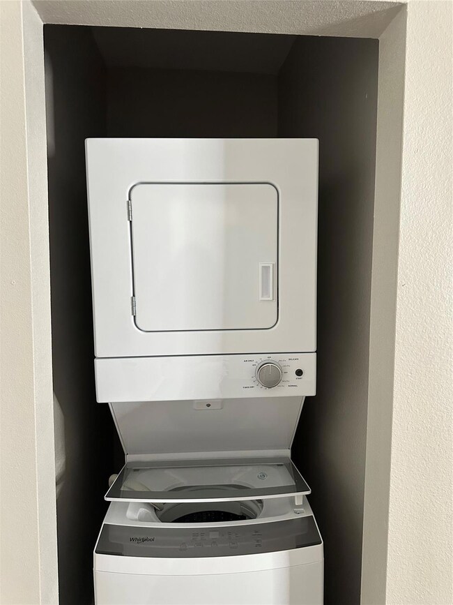 Washroom featuring stacked washer and dryer and a 