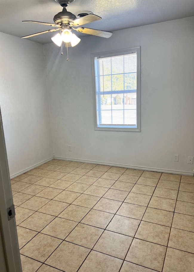 Empty room featuring light tile patterned floors, a ceiling fan, and a textured ceiling