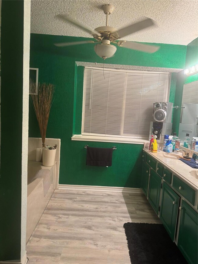 Bathroom with vanity, a textured ceiling, wood-typ
