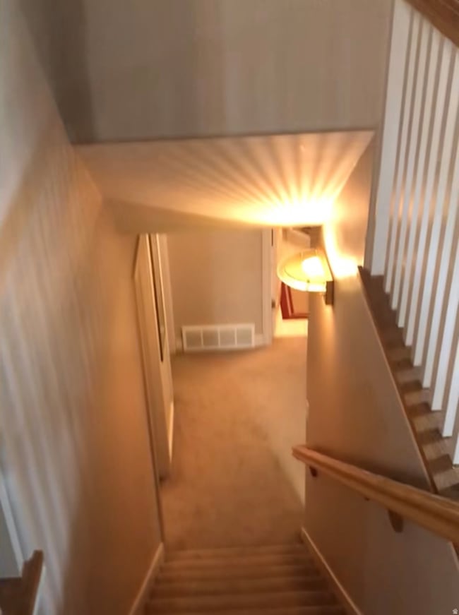 Staircase with carpet floors and baseboards