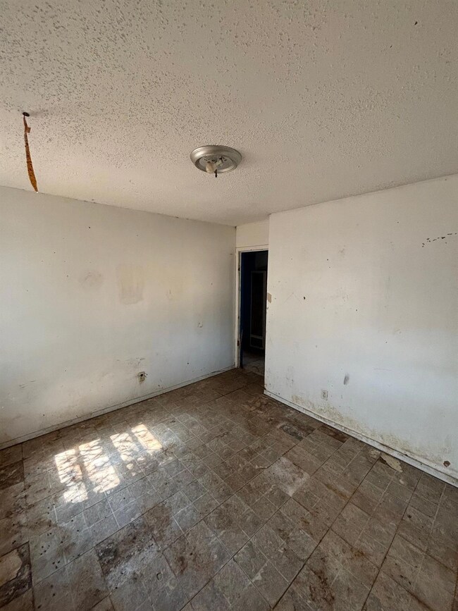 Tiled empty room featuring a textured ceiling