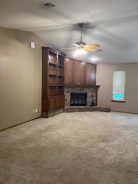 Unfurnished living room with light carpet, a brick