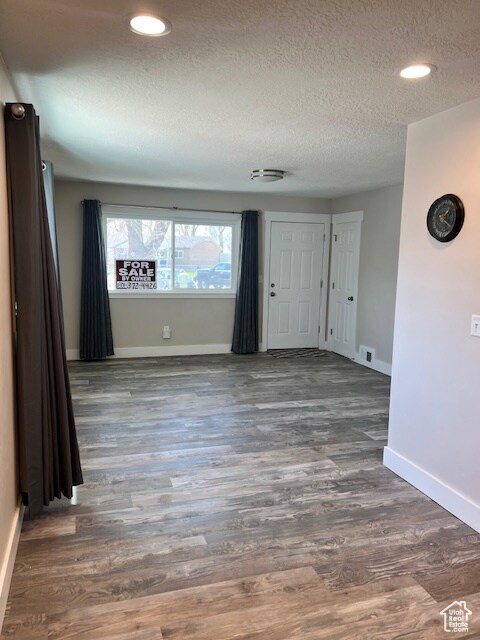 Unfurnished room featuring a textured ceiling, wood finished floors, and recessed lighting