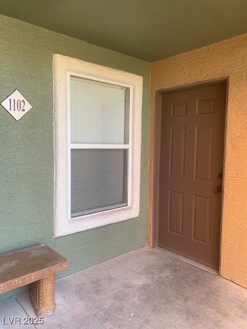 Doorway to property with stucco siding