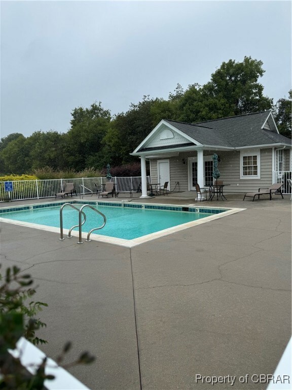View of pool with a patio area and clubhouse