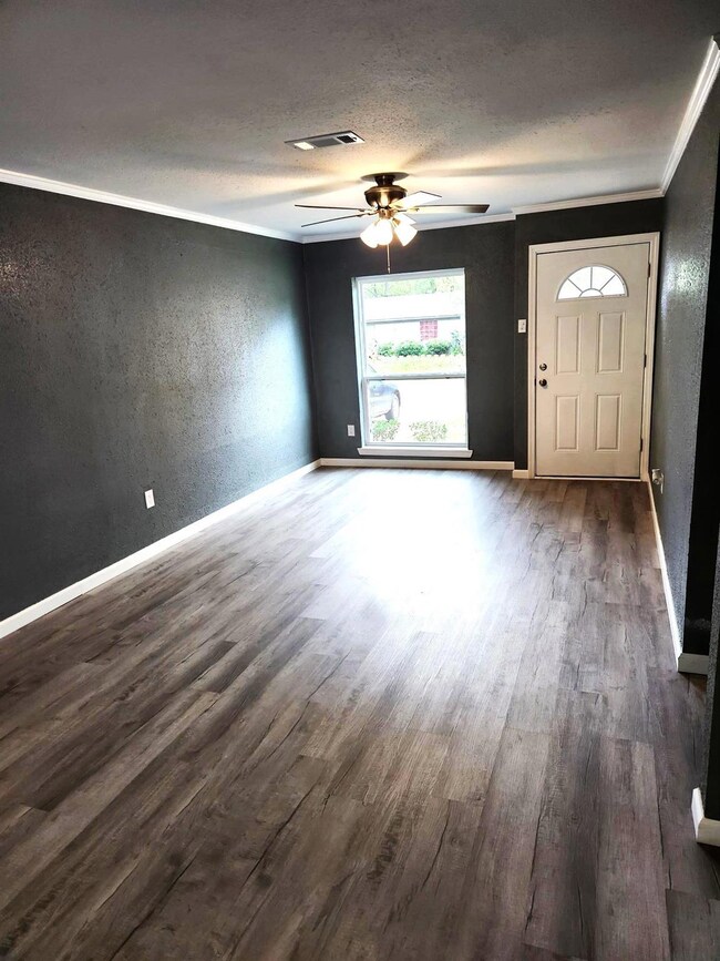 Foyer with ornamental molding, ceiling fan, and da
