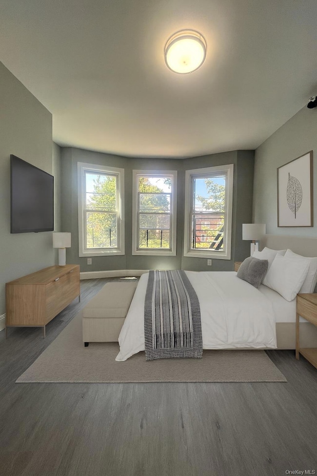 Bedroom featuring wood finished floors and multiple windows