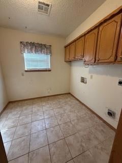 Clothes washing area featuring cabinet space, ligh