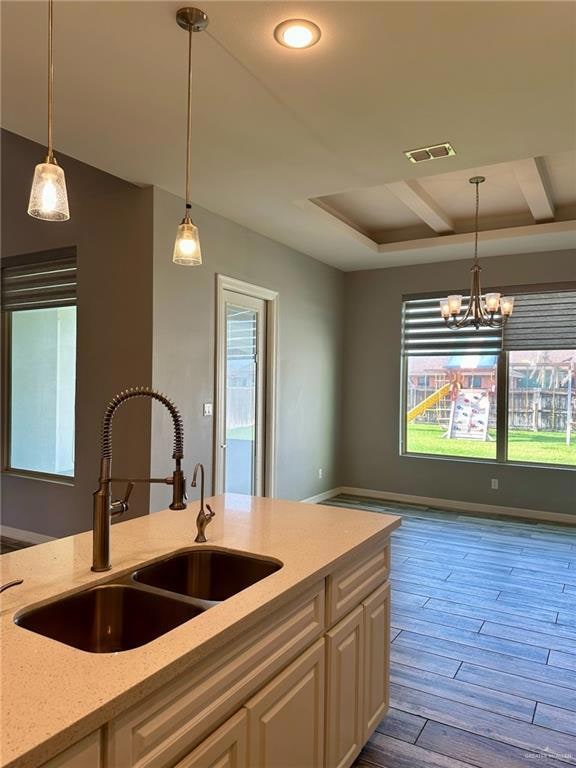 Kitchen with light stone counters, white cabinets, wood finished floors, healthy amount of natural light, and recessed lighting