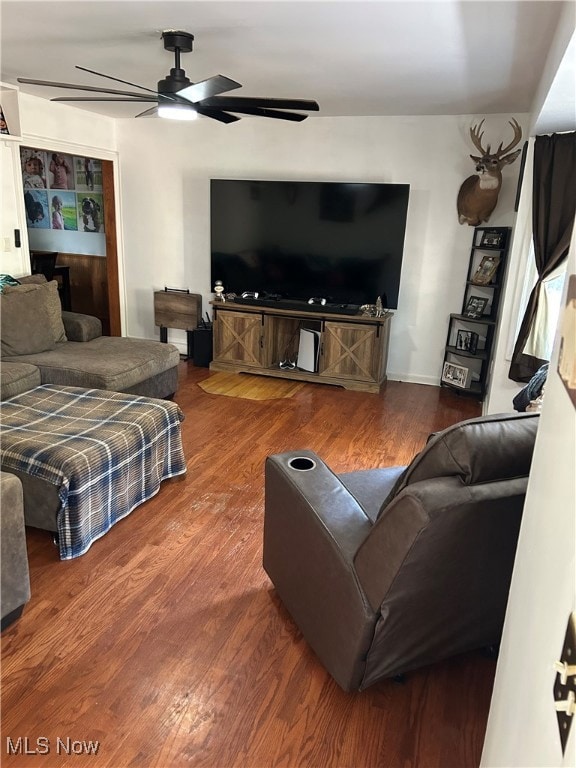 Living area featuring wood finished floors and a ceiling fan