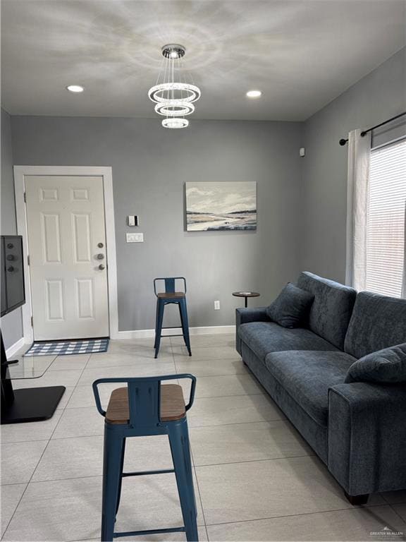 Living room featuring light tile patterned flooring, baseboards, recessed lighting, and a chandelier