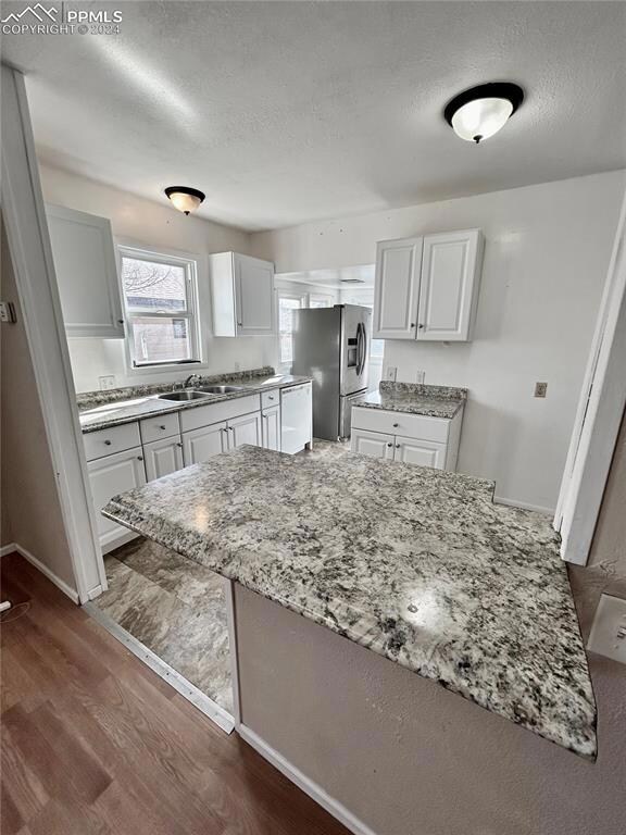 Kitchen with stainless steel fridge, light stone c