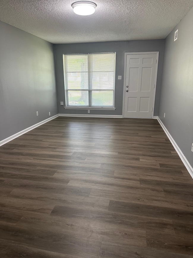 Entryway featuring dark wood-style flooring, a textured ceiling, and baseboards