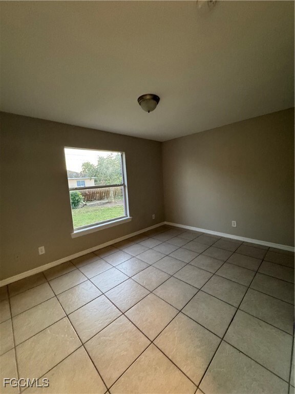 Unfurnished room with light tile patterned flooring