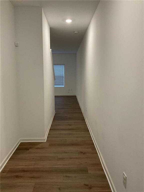 Hall with baseboards and dark wood-style floors