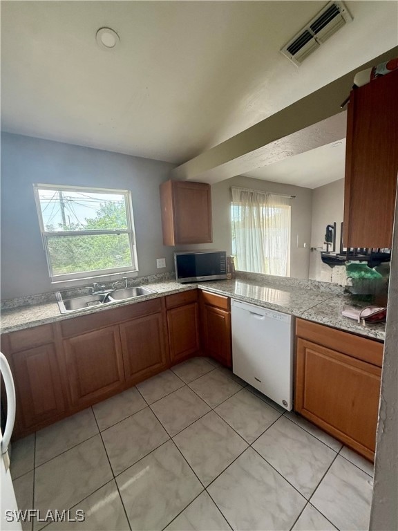 Kitchen with white dishwasher, healthy amount of n