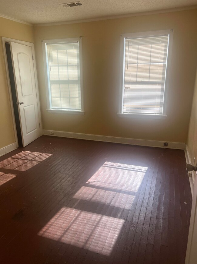 Empty room featuring visible vents, hardwood / woo