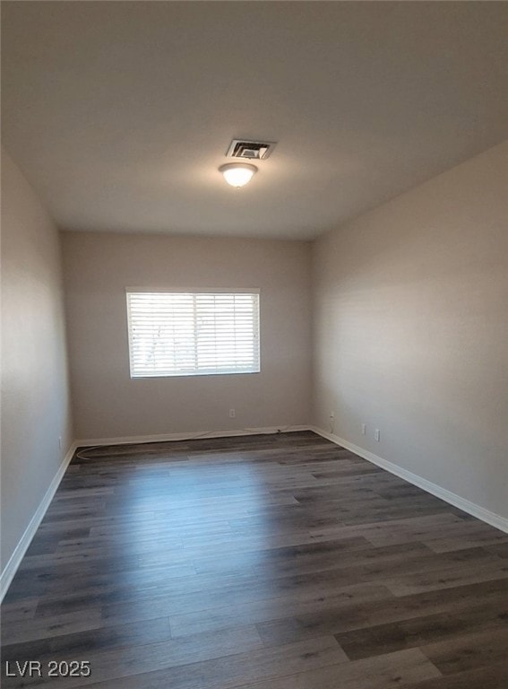 Spare room featuring dark wood-style flooring and