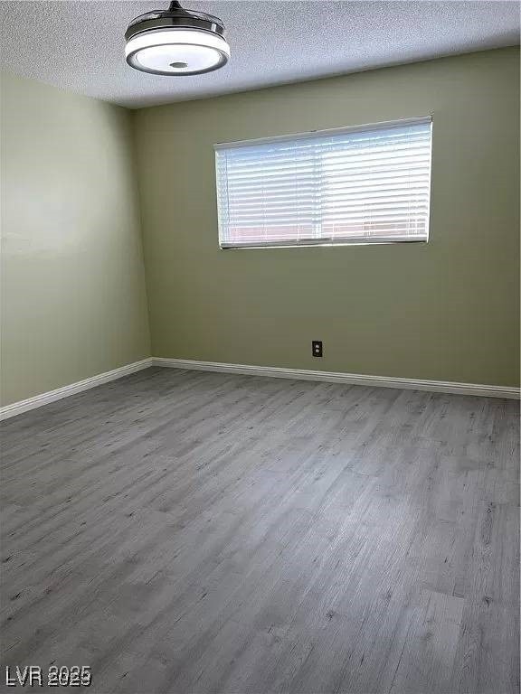 Empty room featuring wood finished floors, baseboa