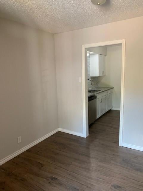 Spare room with baseboards, dark wood-style floori