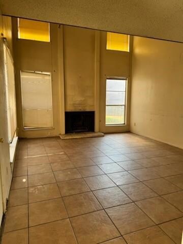 Downstairs living room with a high ceiling, a fire