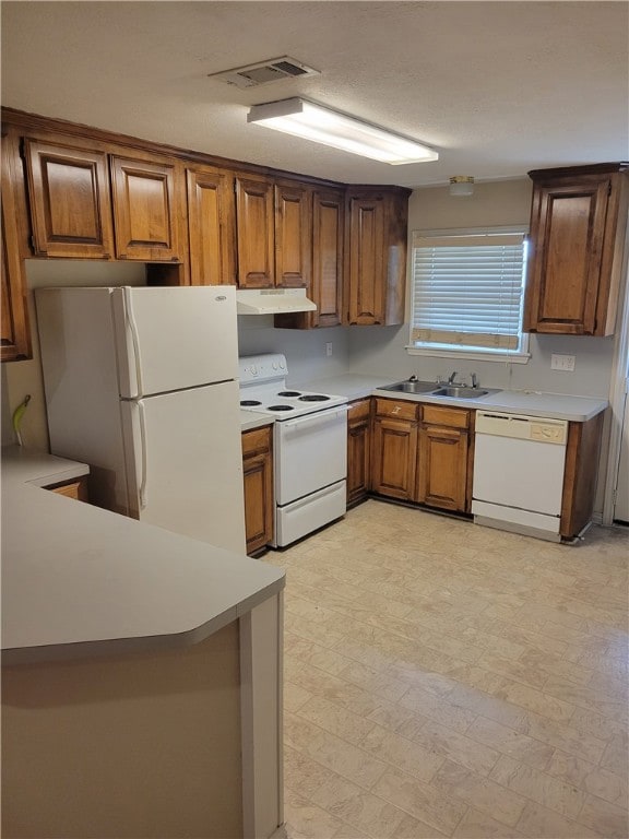 Kitchen featuring a sink, light floors, brown cabi