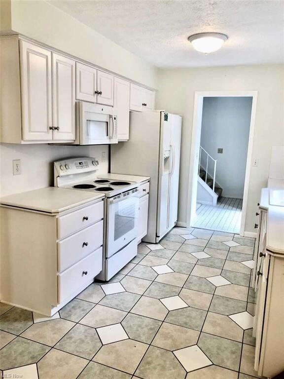 Bright, white kitchen located at the front of the condominium, please note microwave is not in working order.