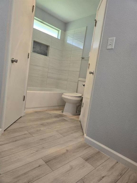 Bathroom featuring toilet, wood finished floors, 