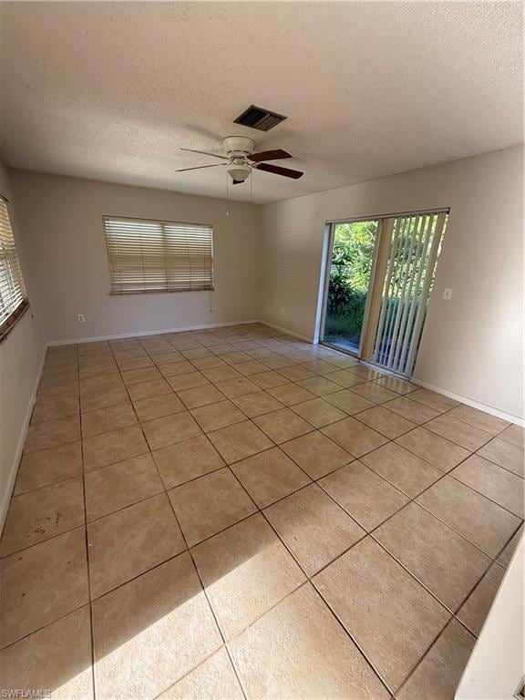 Unfurnished room featuring a textured ceiling, tile patterned flooring, and ceiling fan