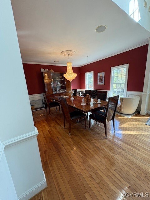 Dining room featuring wood-type flooring and crown