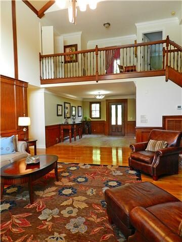 The living room all features full paneled walls and stately cherry ceiling beams