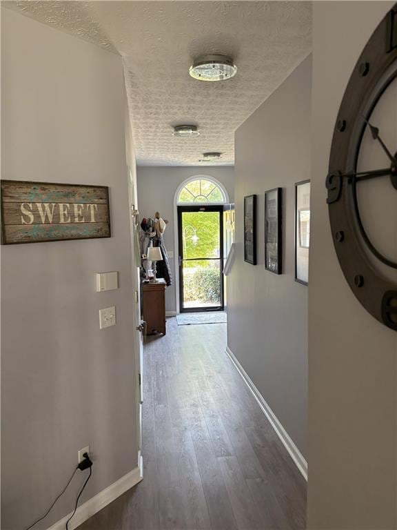Hall featuring a textured ceiling and wood finished floors