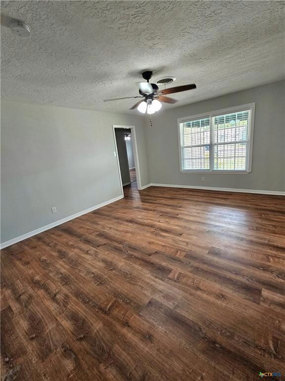 Empty room featuring baseboards, a textured ceili
