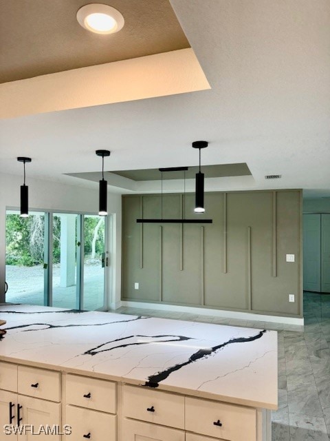 Kitchen with a tray ceiling, light marble finish f
