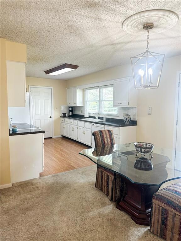 Dining area with a textured ceiling and light colored carpet