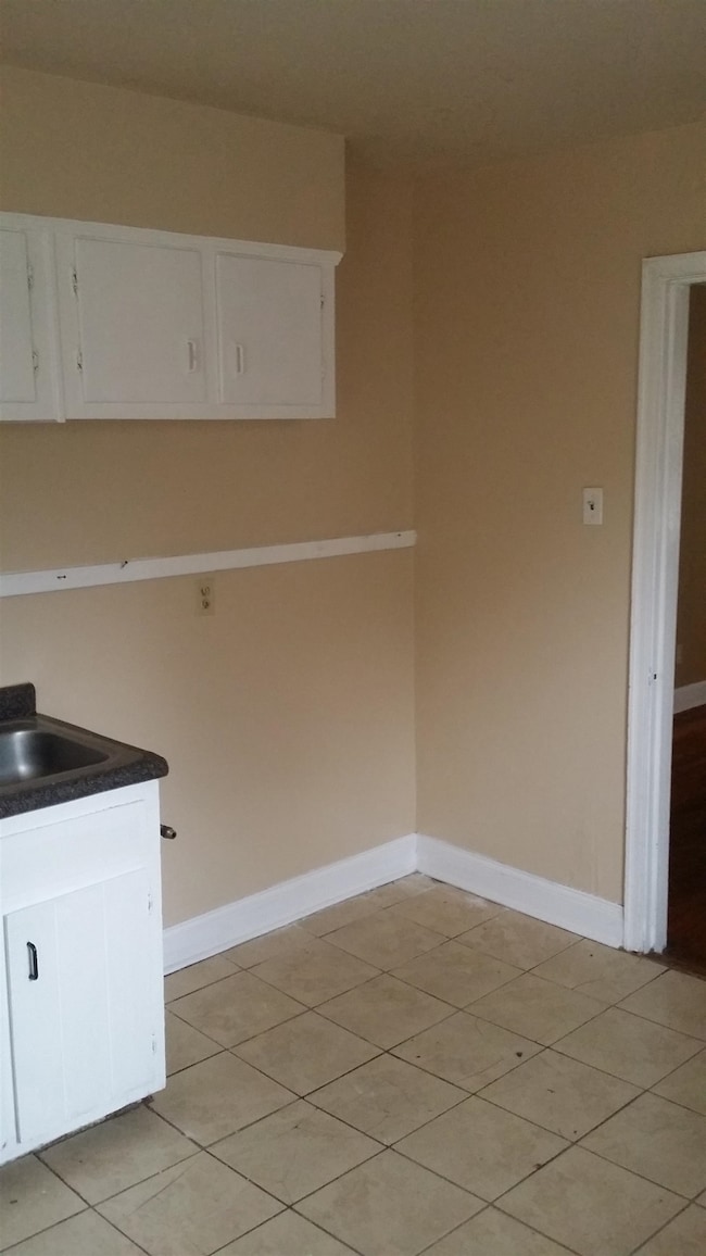 Kitchen with white cabinetry, dark countertops, and light tile patterned floors