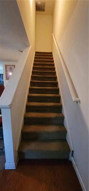 Stairway featuring hardwood / wood-style floors