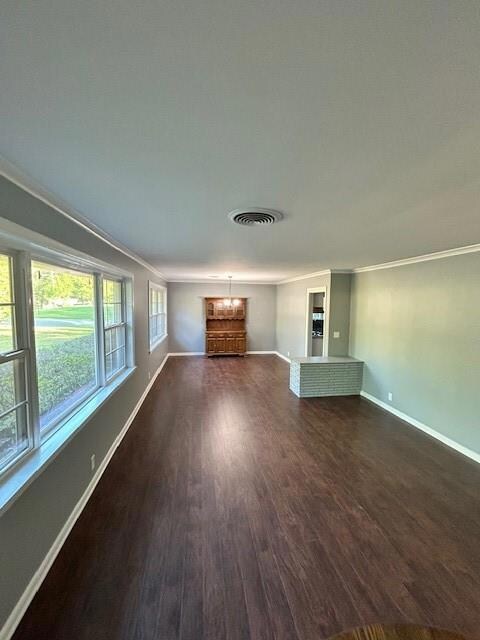 Unfurnished living room with crown molding and dar