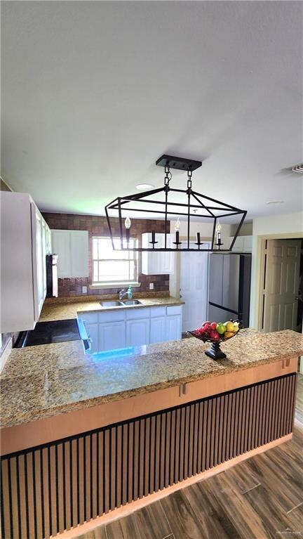 Kitchen with wood finished floors, freestanding refrigerator, and range