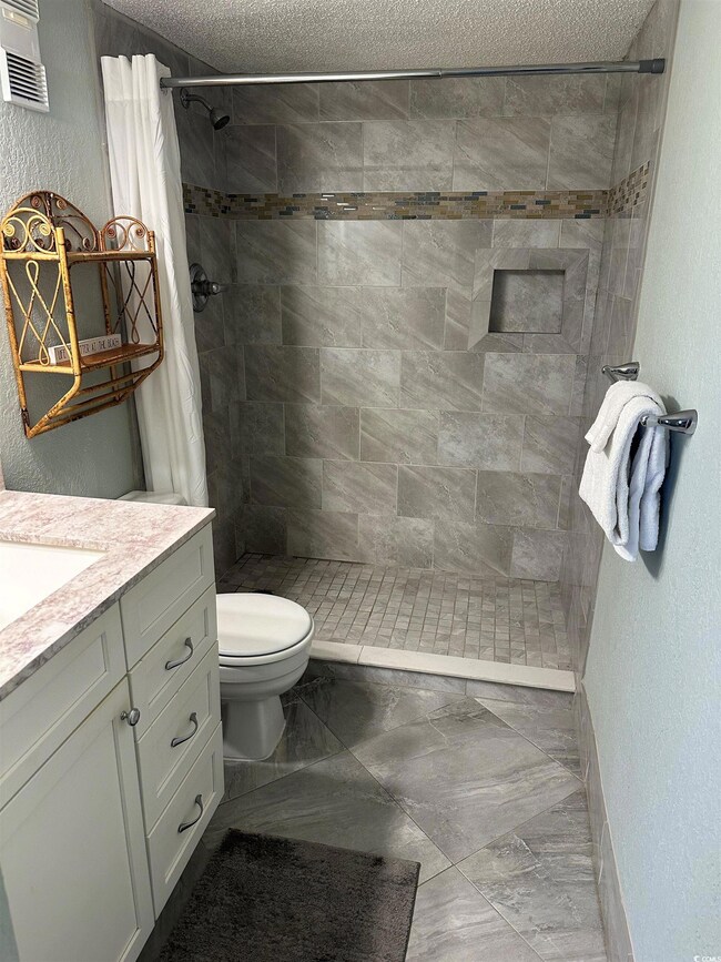 Bathroom featuring a textured ceiling, tile patter