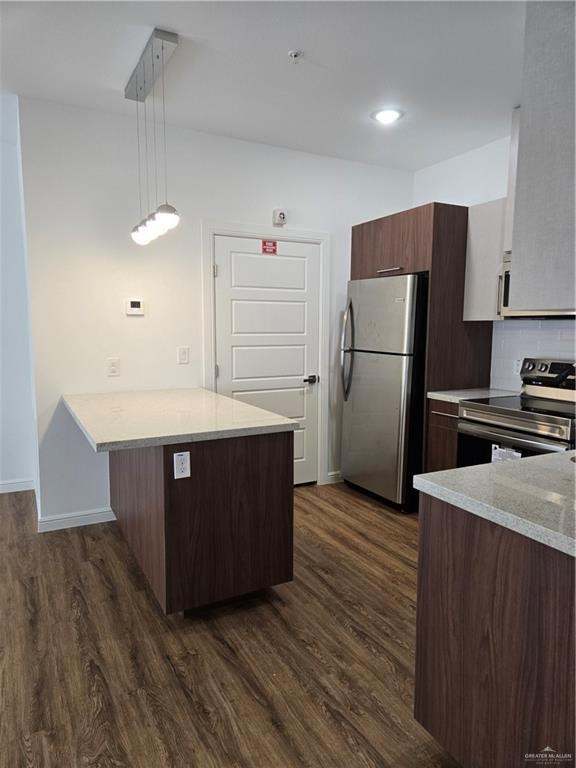Kitchen featuring refrigerator, a peninsula, dark wood-style floors, and range