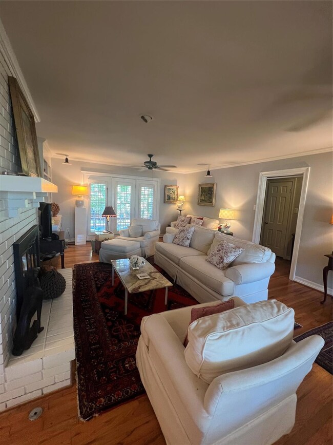 Living room featuring brick wall, a fireplace, cei