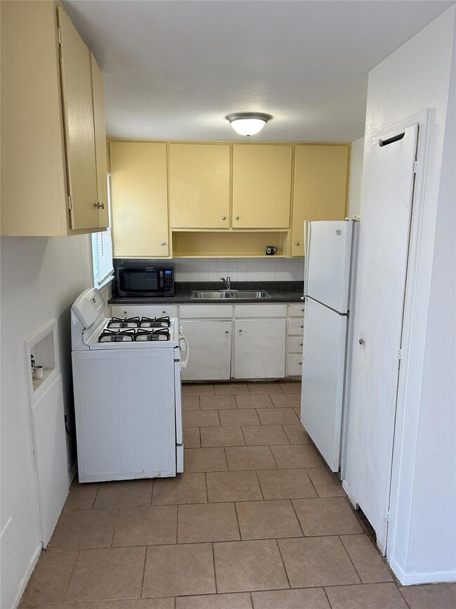Kitchen featuring white appliances, sink, and tast