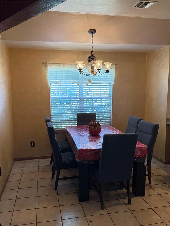 Dining space featuring a chandelier and light tile patterned floors